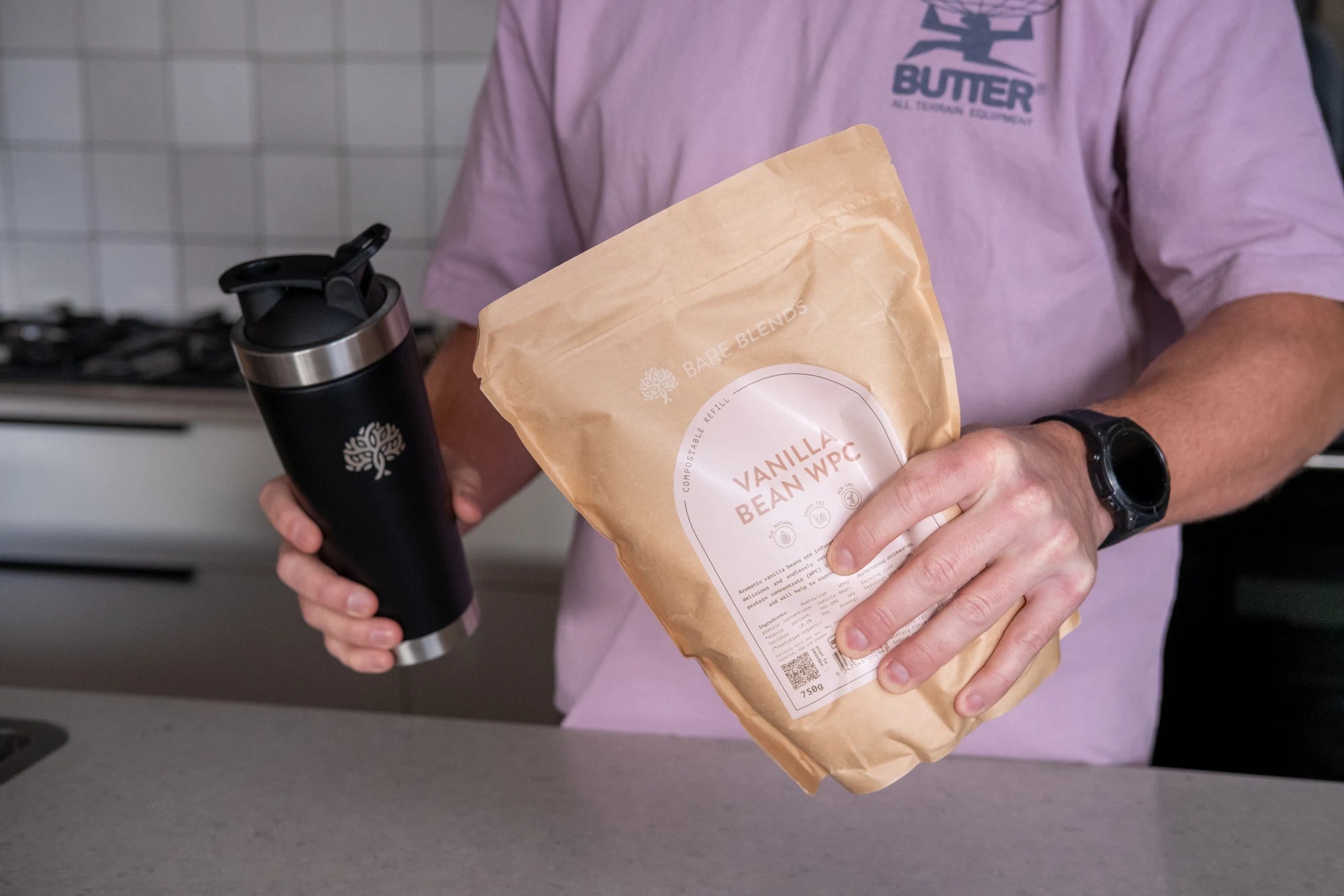 Person holding Bare Blends Vanilla Bean WPC and a black Bare Blends shaker